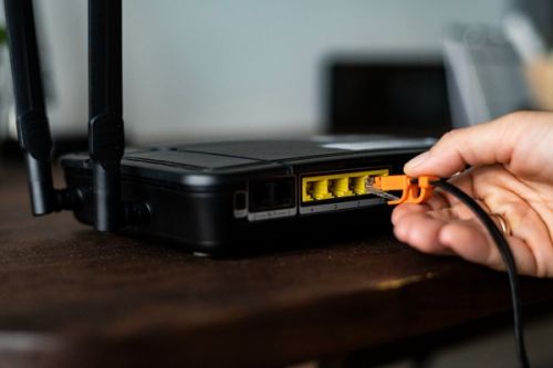wireless router being plugged in with ethernet cable